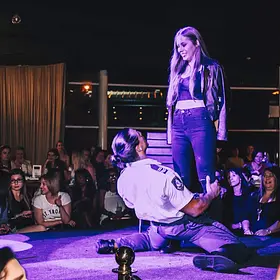 Centre Stage Surprise Male stripper performing on stage for a standing guest while a large crowd watches and cheers during a live show.
