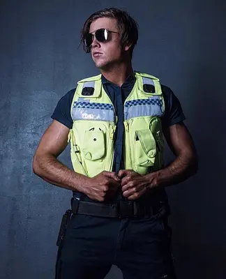 Sunshine Coast entertainer Tyler posing in sunglasses and a high-visibility police officer costume during a dramatic studio photoshoot.