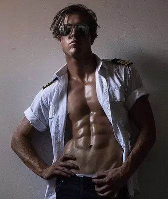 Sunshine Coast entertainer Tyler posing in sunglasses and an open white pilot shirt during a moody promotional photoshoot.