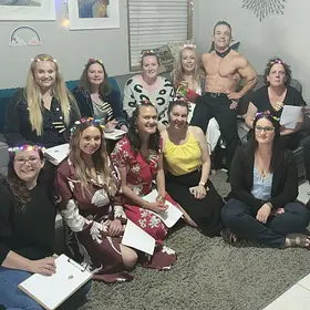Perth’s Pocket Rocket David posing shirtless with a group of smiling women holding sketchpads after a fun private life drawing hens party.