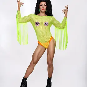 Brisbane QLD drag queen Tara Zaan striking a theatrical pose in a neon green fringed bodysuit with black hair, bold makeup and black ankle boots.