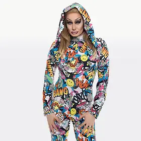 Pop Art Comic Print Drag Performer A drag queen with blonde hair wearing a hooded bodysuit featuring a vibrant pop-art comic book print with "BANG," "WOW," and smiley face motifs.
