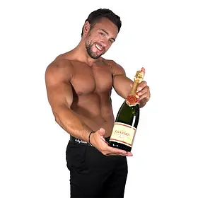 A charming, muscular topless waiter in Sydney leaning toward the camera while presenting a chilled bottle of Grandin champagne with a warm smile. He provides professional bubbly service, interactive hosting, and premium male entertainment for hens parties and bachelorette celebrations across Sydney and the NSW region.