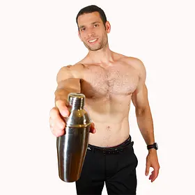 A muscular, shirtless male host for Sydney entertainment hire smiling while holding a cocktail shaker out toward the camera. He offers premium drink service and topless waiters for hire at hens parties and bachelorette events throughout Sydney, NSW.