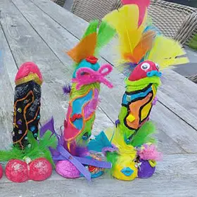Alt Text: Three vibrant, maximalist creations from a paint your plaster penis workshop, heavily decorated with neon feathers, pipe cleaners, googly eyes, and glitter. These naughty risqué moulds are a signature of our mobile hens party entertainment available Australia-wide.