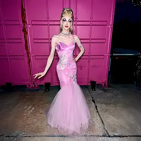 Brisbane drag queen Ann Xiety wearing a glamorous pink evening gown and posing in front of a pink backdrop.