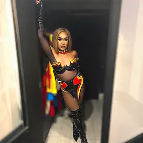 Perth drag queen Moesha posing in a fire-inspired performance costume with thigh-high boots and dramatic stage styling.