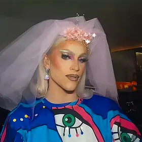 Lola Blades Bride Of The Night Look Perth drag queen Lola Blades wearing a large bridal veil and colourful outfit while posing at a nightlife event.