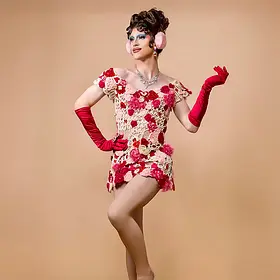 Perth drag queen Lola Blades wearing a floral couture dress with pink gloves and dramatic blue makeup in a studio portrait.