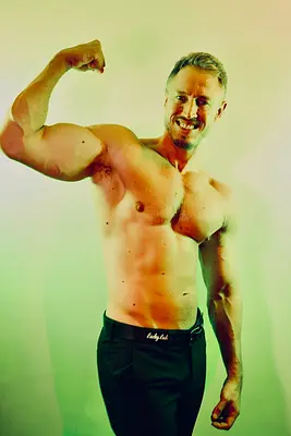 Sydney entertainer Adam smiling and flexing his arm shirtless, available for hens parties, hens nights and birthday celebrations.
