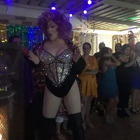 Delvira Working The Crowd Perth drag queen Delvira entertaining guests in a sparkling bodysuit, purple wig and thigh-high boots, available to hire for parties and events.